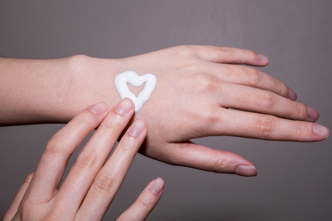 Woman applying moisturizing cream on hands